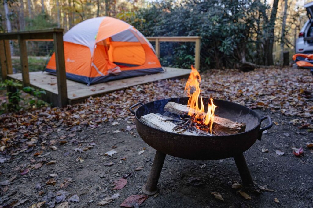 Campfire with orange tent in the background