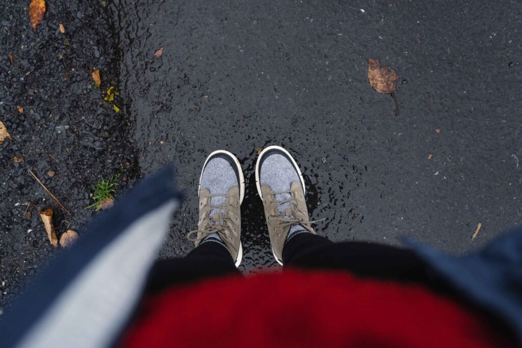 Woman wearing the Sorel Explorer II Joan Boots on a rainy day 
