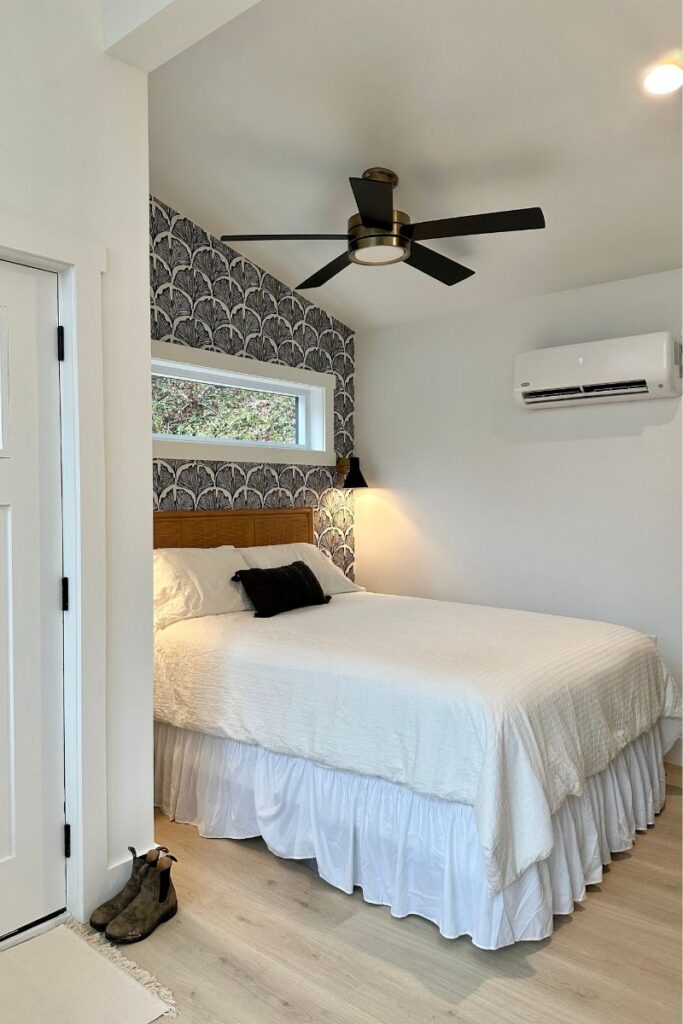 Tiny house bedroom with tall ceilings and white bedding